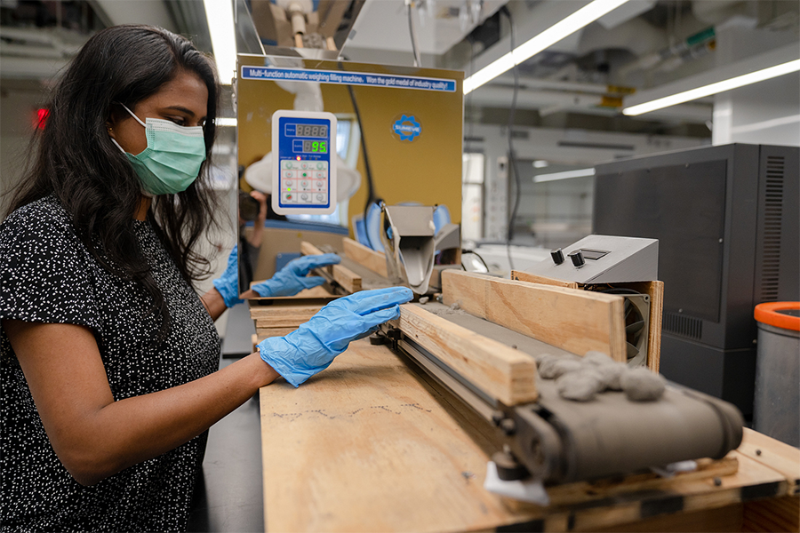 Female student sanding wood in a lab