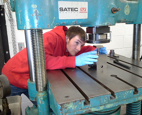 Man looking closely at part of a table-top machine